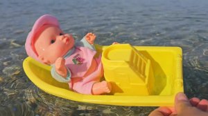 Baby doll playing and swimming on the beach