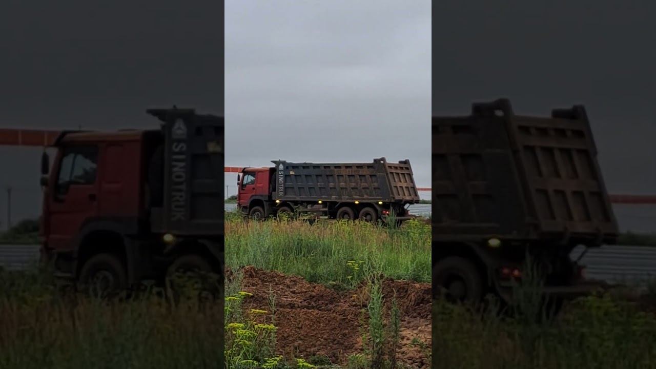 A red dump truck carries soil.