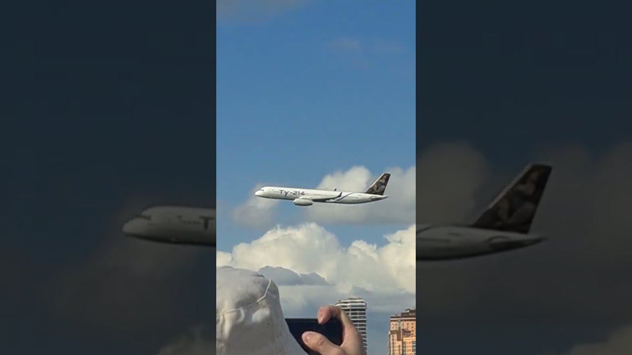 A Tu-214 plane flies over the city.