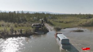 Вездеход перетаскивают Уралы через реку в Якутии тросом