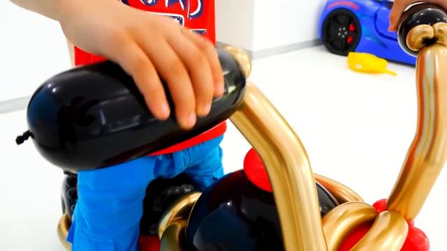 Влад и Никита играют с игрушечной машиной из воздушных шаров