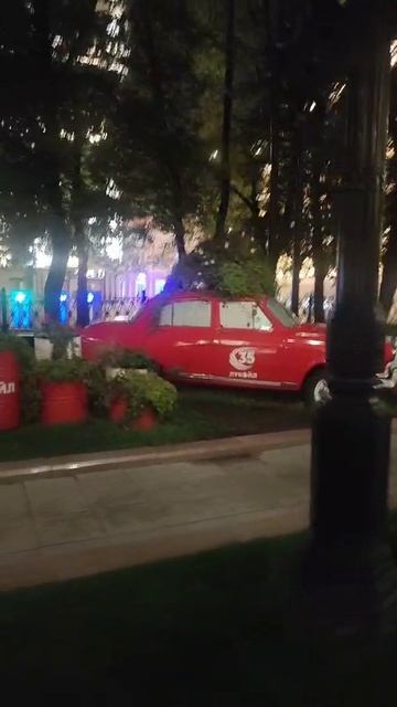 Красная Волга на газоне в парке Москвы.