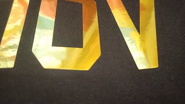 золотая надпись на футболке