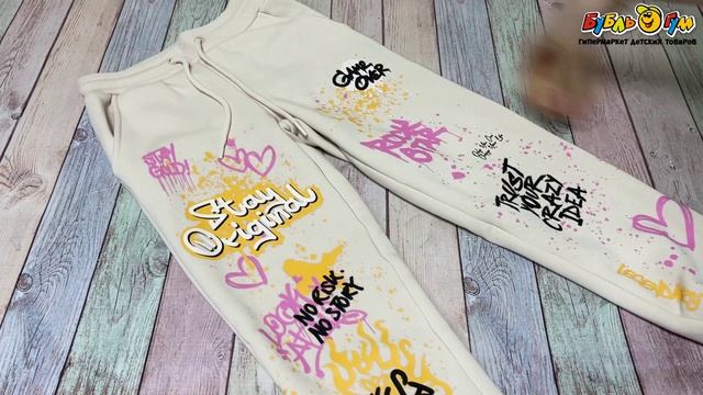 Брюки утепленные Lanson Kids на эластичном поясе со шнурком с карманами и эластичными манжетами на штанинах с ярким граффити принтом бежевые - видео