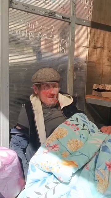 Жители помогают мужчине, который ночует на остановке возле эстакады на улице Абазинской в Сухуме