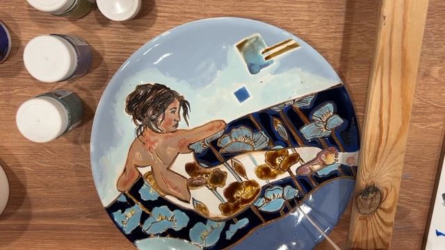 Процесс надглазурной росписи керамической тарелки.