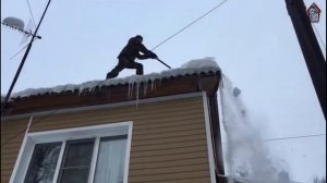 Альпинисты чистят двухскатную кровлю.