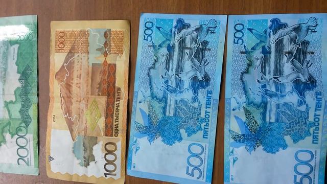 2 БАНКНОТЫ ДВЕ ТЫСЯЧИ, 1 ТЫСЯЧА И 2 ПЯТЬСОТ ТЕНГЕ лежат оборотом на светло-корич. поверхн. 16 Июня смотреть онлайн