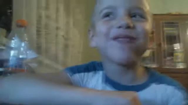 Мальчик ест сосиску