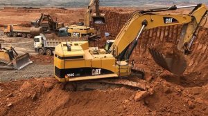 Caterpillar 365C загружает грузовики