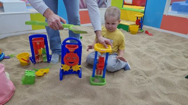 A child plays in the sandbox and pushes a train on the playground смотреть онлайн