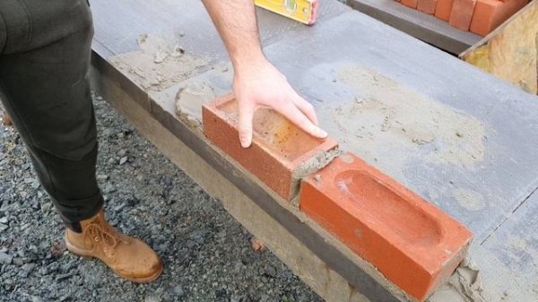 Bricklayer teaches novice (Big G) how to lay bricks...