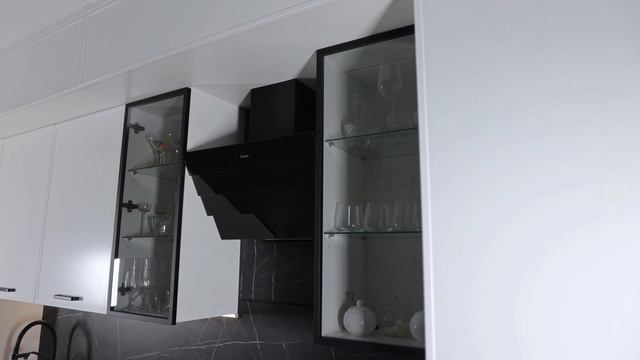 Обзор кухни с белыми фасадами, шкафом-витриной и трендовой столешницей