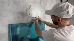 Монтаж зеркала с подсветкой в ванной комнате.