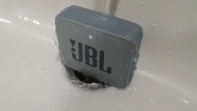 Портативная колонка JBL GO2 под струёй воды. смотреть онлайн