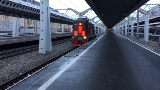 ТЭМ18В-020. Выезжает из под пассажирского поезда, и ЧС2Т-?. На заднем плане.