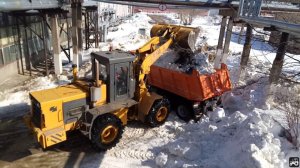 Фронтальный погрузчик В-138 грузит Камаз снегом