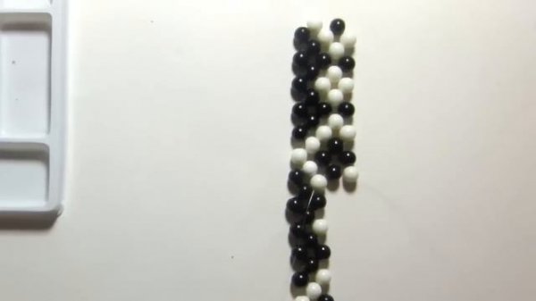 Pulsera brazalete con bolas blancas y negras.