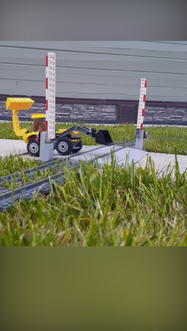 Игрушечные машинки едут через жд переезд