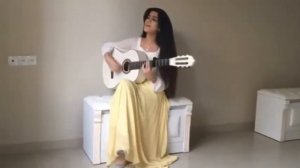 девушка красиво играет на гитаре и поет душевно