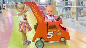 Настя развлекается на аттракционах с любимой куклой