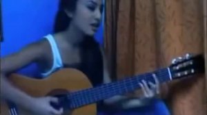 Девушка красиво играет на гитаре и поет песню на иностранном языке