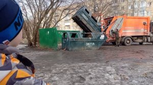 Мусоровоз загружает мусор.