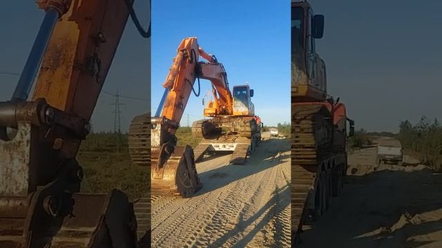 экскаватор съезжает с тралла