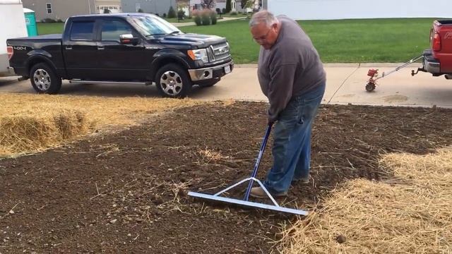 Lawn installation tips. Using a wide landscape rake to level the soil before seeding. смотреть онлайн