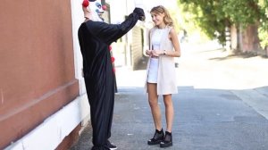 Парень в костюме клоуна целует незнакомых девушек