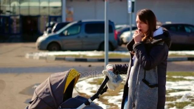 An Irresponsible Mom Smokes And Looks Around. Baby In A Stroller