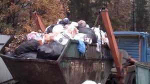 Загрузка большого мусорного контейнера.