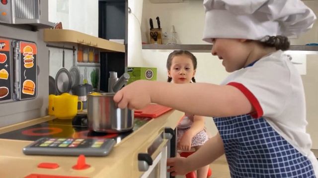 Николь и Филипп играют в кафе. Дети играют игрушечной кухней.