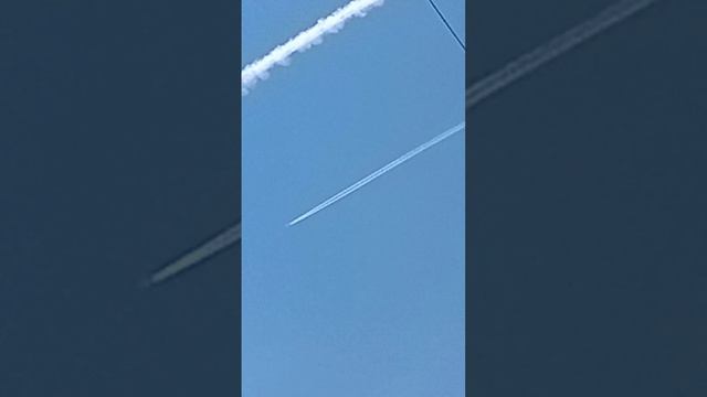 След на небе оставил самолёт, который распыляет химикаты, а рядом летит пассажирский самолёт... смотреть онлайн