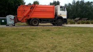 Погрузка мусора на мусоровозе. Мусоровоз с контейнерами на озере. Задняя загрузка.