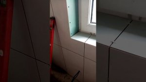 Оконный откос из плитки в ванной.,запил под 45градусов.