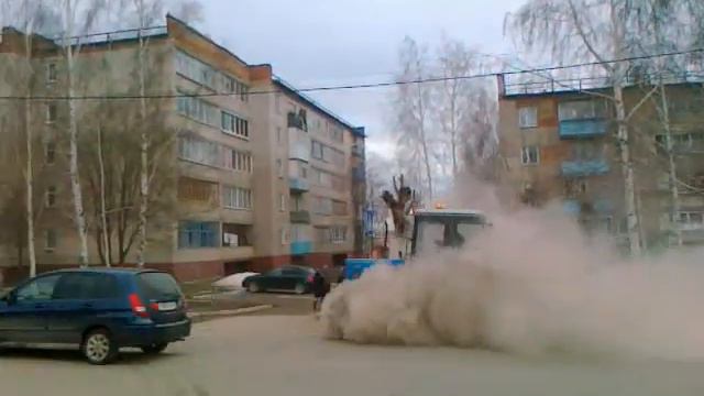 Трактор поднимает пыль на улицах города. смотреть онлайн