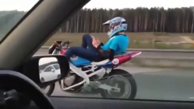 Бесстрашный мотоциклист лежа едет смотря в телефон [480p] смотреть онлайн