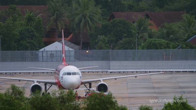 Эйрбас А320 авиакомпании Thai AirAsia в аэропорту Пхукета. Буксировка перед вылетом.