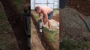 Копание фундамента с помощью отбойного молотка и смонтированной к нему лопаты