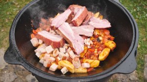 Микс из копченого мяса с картофелем в казане на костре.