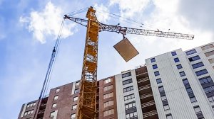 Работа башенных кранов на стройке.