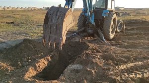 Экскаватор ЮМЗ, копает и вытаскивает камни