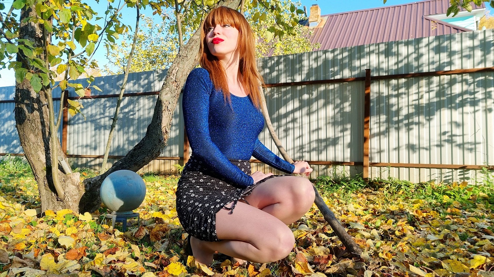 Длинноногая рыжая девушка в бежевых колготках и на каблуках танцует под яблоней и ходит по листве смотреть онлайн