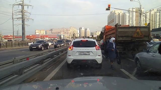 ОКЛО Митинского радиорынка ,на перекрестке мужик переодетый в бабку просят деньги