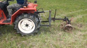 Японский мини трактор пашет плугом целину суглинок каменистый.