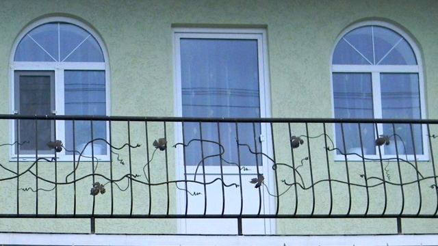 Арочные окна в частном доме выходят на балкон с коваными перилами из металла смотреть онлайн