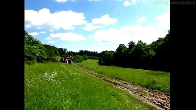 Трактор тащит грузовик груженный брёвнами. смотреть онлайн