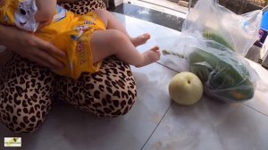 Mom Thuy is breastfeeding at home as daily routine for baby while she is doing cooking...