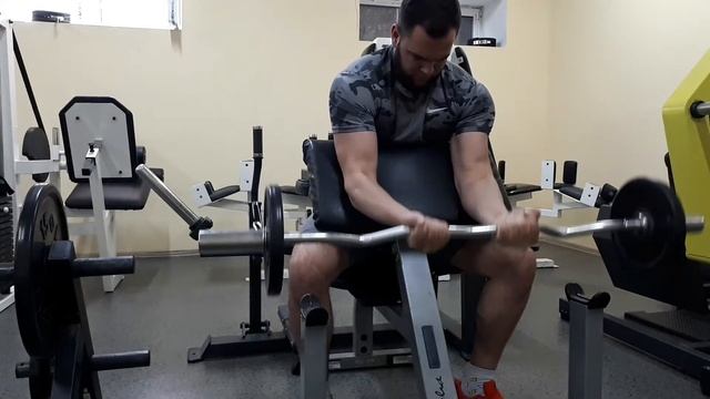Подъем штанги на бицепс на скамье Скотта